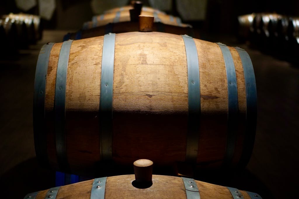 Barrels in a shadowed winery cellar, perfect for wine aging imagery.